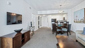 A modern living room with a TV, wooden cabinet, and a dining area with a chandelier. - Inspiring view, relaxing ambience, family favorite (Destin)