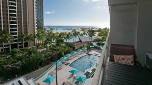 A hotel balcony with a view of the beach, a swimming pool, and palm trees. - Ilikai 640 Ocean / Lagoon Views / Queen Bed, Sofa Bed (Waikiki)