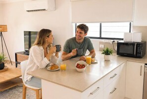 Une cuisine moderne dotée d’un îlot central, d’un four à micro-ondes et d’un lave-vaisselle.