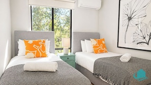 A hotel room with two beds, a window with a view of trees, a wall-mounted air conditioner, and a framed artwork. - Charlottes Rhapsody - Bush and Lake Views (Bonnells Bay)