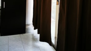 A room with a sliding glass door, a black wardrobe, and tiled flooring. - Ocean Front Boutique (Playa del Carmen)