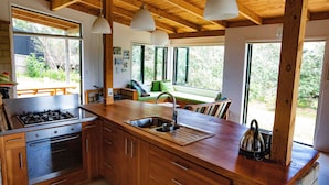 Una cocina con armarios de madera, estufa integrada y un ventanal grande.