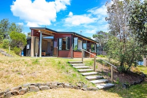 Een modern huis met een stenen trap die leidt naar een houten terras.