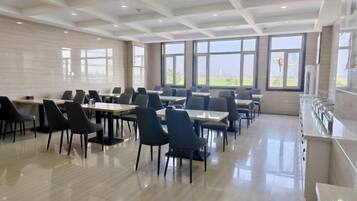 A dining area with tables and chairs arranged for seating.