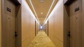 A hotel hallway with carpeted floors, wooden doors, and overhead lighting. - Super 8 Hotel Select Panjin Liaodongwan New Zone Binhai Avenue (Panjin)