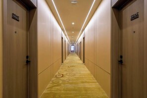 A hotel hallway with carpeted floors, wooden doors, and overhead lighting. - Super 8 Hotel Select Panjin Liaodongwan New Zone Binhai Avenue (Panjin)