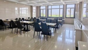 A dining area with tables and chairs, large windows, and a view of the outdoors. - Super 8 Hotel Select Panjin Liaodongwan New Zone Binhai Avenue (Panjin)