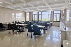A dining area with tables and chairs, large windows, and a view of the outdoors. - Super 8 Hotel Select Panjin Liaodongwan New Zone Binhai Avenue (Panjin)