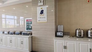 A hotel reception area with a counter, a coffee machine, and a sign indicating room number 8.