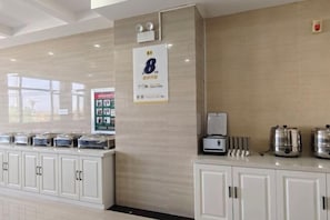 A hotel reception area with a counter, a coffee machine, and a sign indicating room number 8.