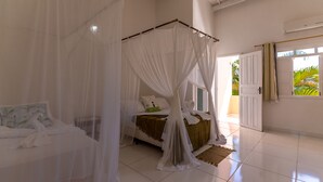 A bedroom with a four-poster bed, white curtains, and a view of the outdoors. - In Trancoso, a beautiful space for up to 35 people. (Trancoso)