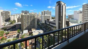 A cityscape with high-rise buildings, a clear blue sky, and a view of the ocean.
