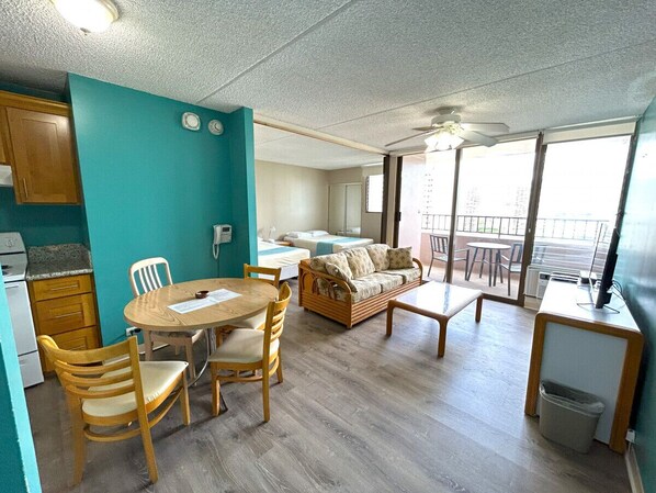 Un espace de vie compact comprenant une kitchenette, un coin repas, un canapé et un balcon avec vue.