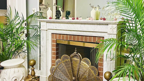 Una sala de estar con chimenea, una mesa de comedor y diversos objetos decorativos.