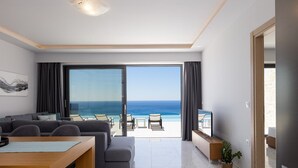 A modern living room with a large sliding glass door leading to a balcony with a view of the ocean. - Brand new villa in Falasarna★Seaview★Infinity pool (Phalasarna)