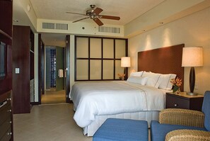 Relax in a traditional room with a large bed, ceiling fan, and a view of the hallway.