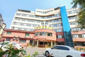 A multi-story hotel with a curved facade, a blue vertical accent, and a clear entrance. - Yizhang Fuhao Hotel (Yizhang)