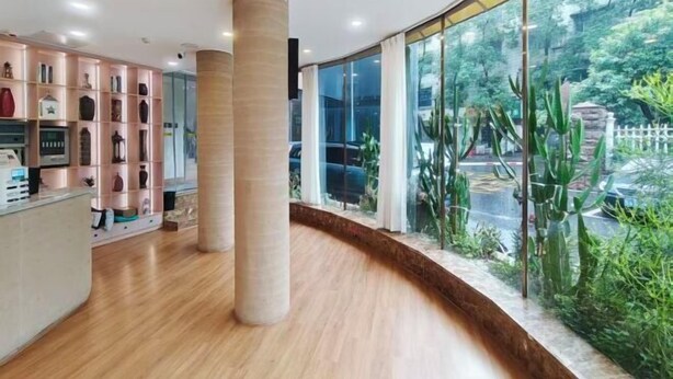 A hotel lobby with a wooden floor, large glass windows, and a reception desk. - Yizhang Fuhao Hotel (Yizhang)