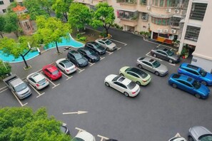 A parking lot with multiple cars, trees, and a building in the background. - Yizhang Fuhao Hotel (Yizhang)