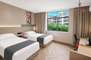 A hotel room with two beds, a desk, a chair, a window with a view of buildings, and a hanging light fixture. - Yizhang Fuhao Hotel (Yizhang)