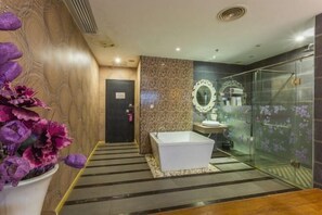 A modern bathroom with a freestanding bathtub, a glass shower enclosure, and a decorative mirror. - Yiyue Express Hotel (Guangzhou)