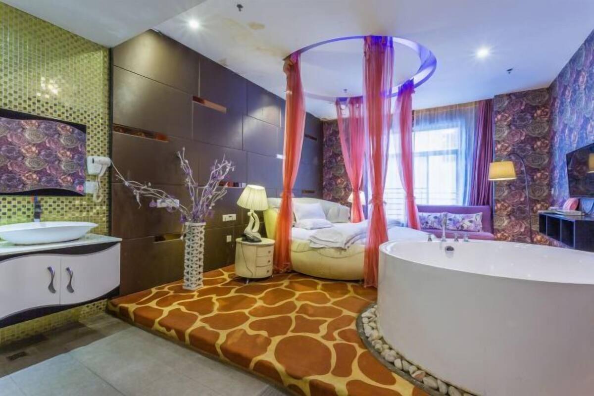A bathroom with a large bathtub, a vanity with a mirror, and a shower area.