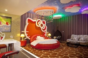 A room with a large Hello Kitty bed, a sofa, a dining area, and a ceiling with a starry design. - Yiyue Express Hotel (Guangzhou)