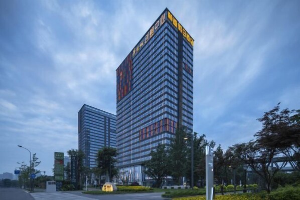 A modern high-rise building with a glass facade and a prominent entrance.