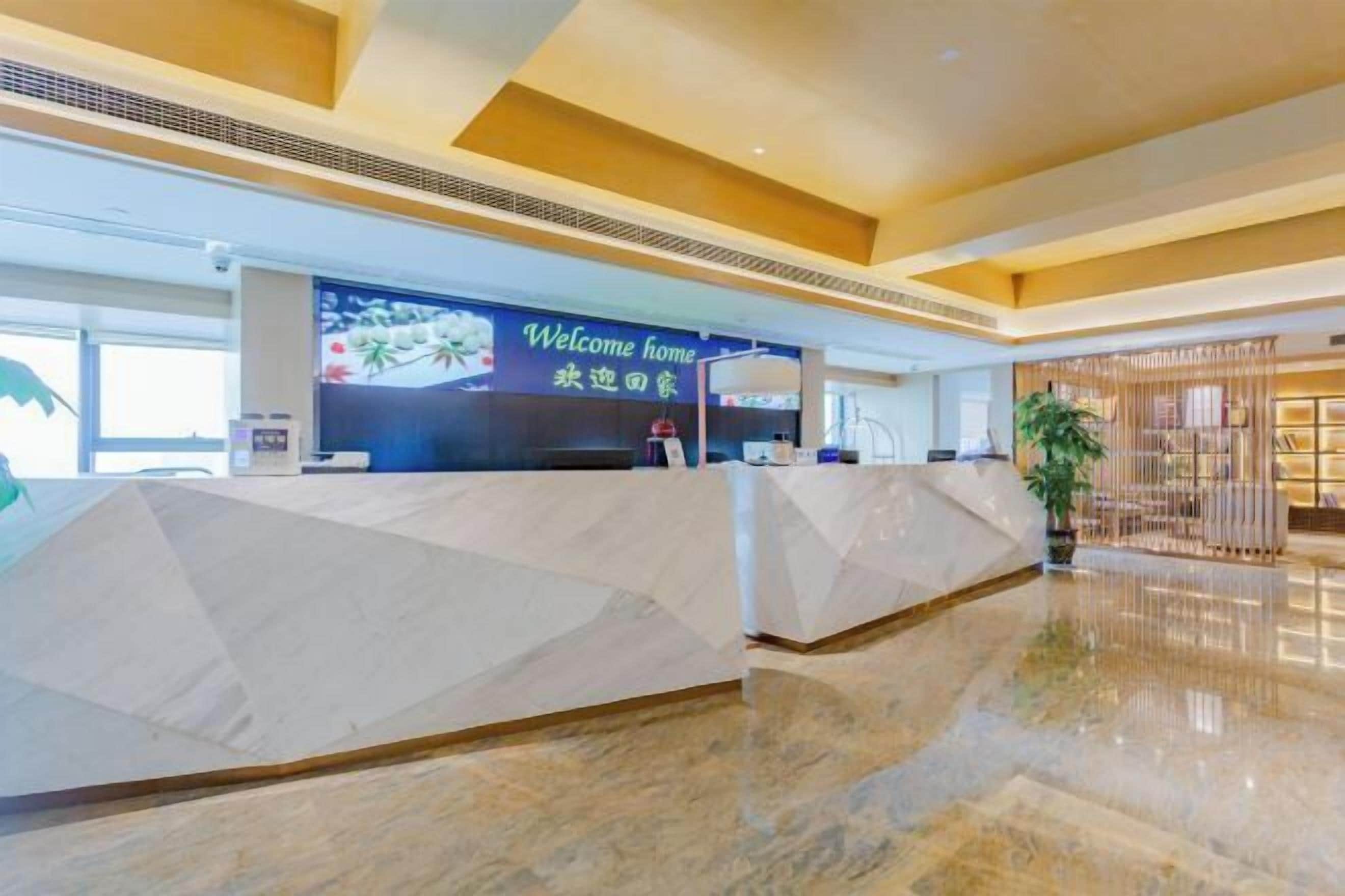 A reception area with a 'Welcome home' sign, a reception desk, and a plant.