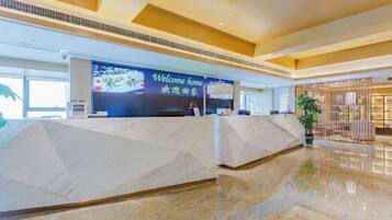 A reception area with a 'Welcome home' sign, a reception desk, and a plant.