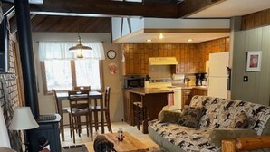 Un salon chaleureux avec un canapé, un chien et une table basse en bois.