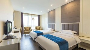 A hotel room with two beds, a desk, a chair, and a TV. - Fuda Fashion Hotel (Chongqing)