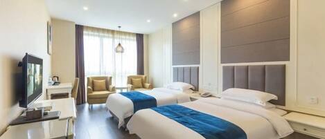 A hotel room with two beds, a desk, a TV, and a window with curtains.