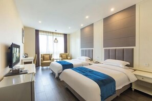 A hotel room with two beds, a desk, a TV, and a window with curtains. - Fuda Fashion Hotel (Chongqing)