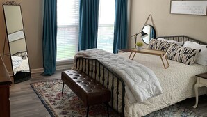 A bedroom with a bed, a bench, a ceiling fan, a mirror, and a rug. - Bluedoor House Comfy Home close to NB, SA, & RAFB (Live Oak)