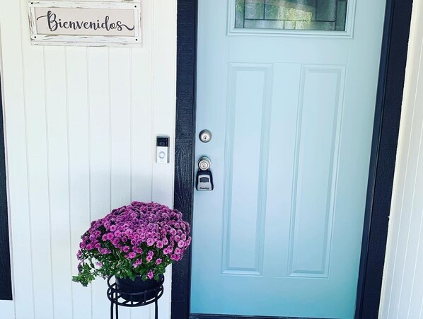 A door with a "Bienvenidos" sign, a doorbell, and a Master key.