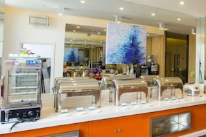 A buffet setup with multiple self-service stations, a coffee machine, and a large abstract painting on the wall. - Kunming Zun Xiang Jin Xuan Boutique Hotel (Kunming)