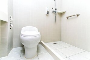 A white toilet in a bathroom with a shower, a handrail, and a soap dispenser on the wall. - Kunming Zun Xiang Jin Xuan Boutique Hotel (Kunming)