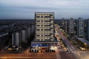 A high-rise building with a modern facade and a large entrance. - Hexi Hotel (Tongliang Wanda Plaza Branch) (Chongqing)