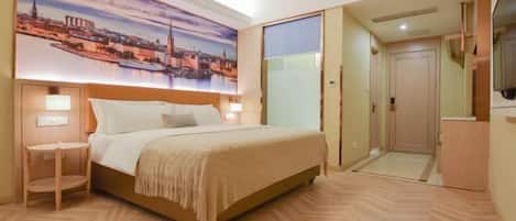 A hotel room with a bed, bedside table, and a large cityscape painting on the wall.
