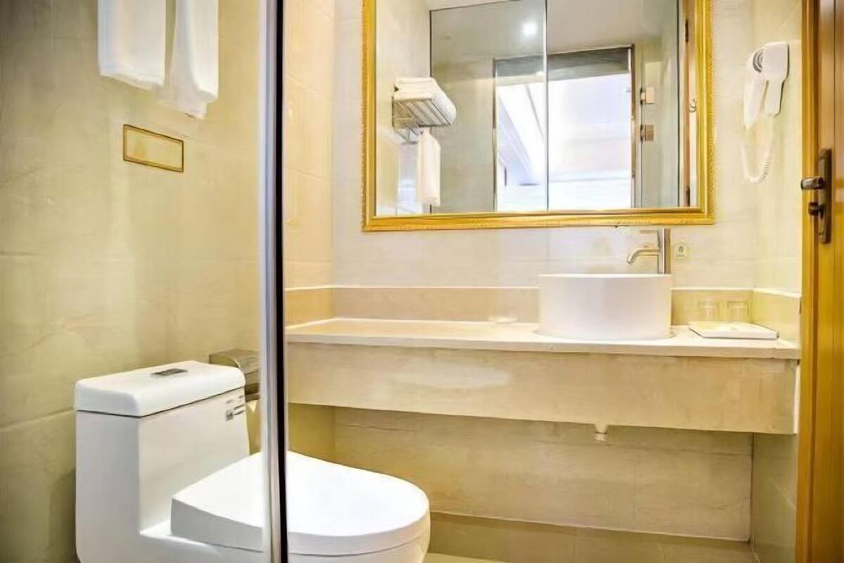 A modern bathroom with a toilet, sink, and mirror.