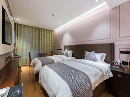 Una habitación de hotel con dos camas, un escritorio y una silla.
