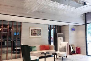 A modern interior with a sofa, chairs, and a small table. - City Comfort Inn (Zhongshan Dongfeng Town Government) (Zhongshan)