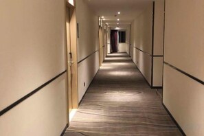 A hotel corridor with carpeted floors, doors on both sides, and a long hallway. - City Comfort Inn (Zhongshan Dongfeng Town Government) (Zhongshan)