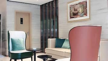 Un moderno vestíbulo de hotel con un sofá, un sillón y una mesita.
