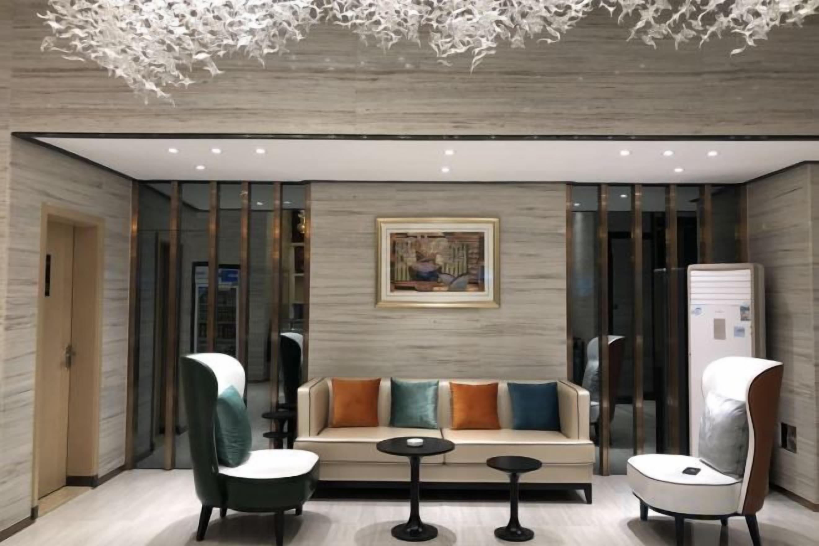 A modern lobby with a sofa, chairs, and tables.