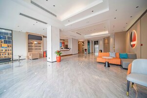 A spacious lobby with a reception desk, seating area, and a modern design.