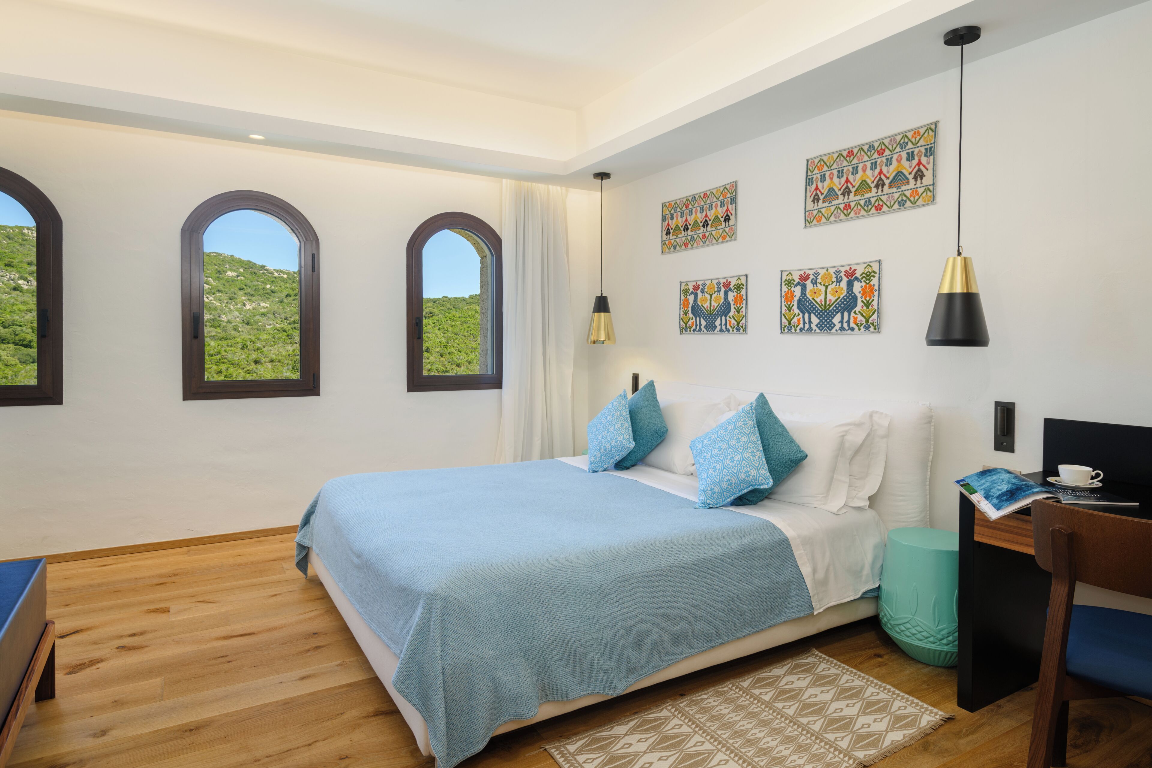 Una camera da letto con un letto, una scrivania, una sedia, una finestra e un quadro appeso al muro.