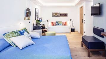 Un dormitorio moderno con una cama grande, un sofá, un televisor y un escritorio.