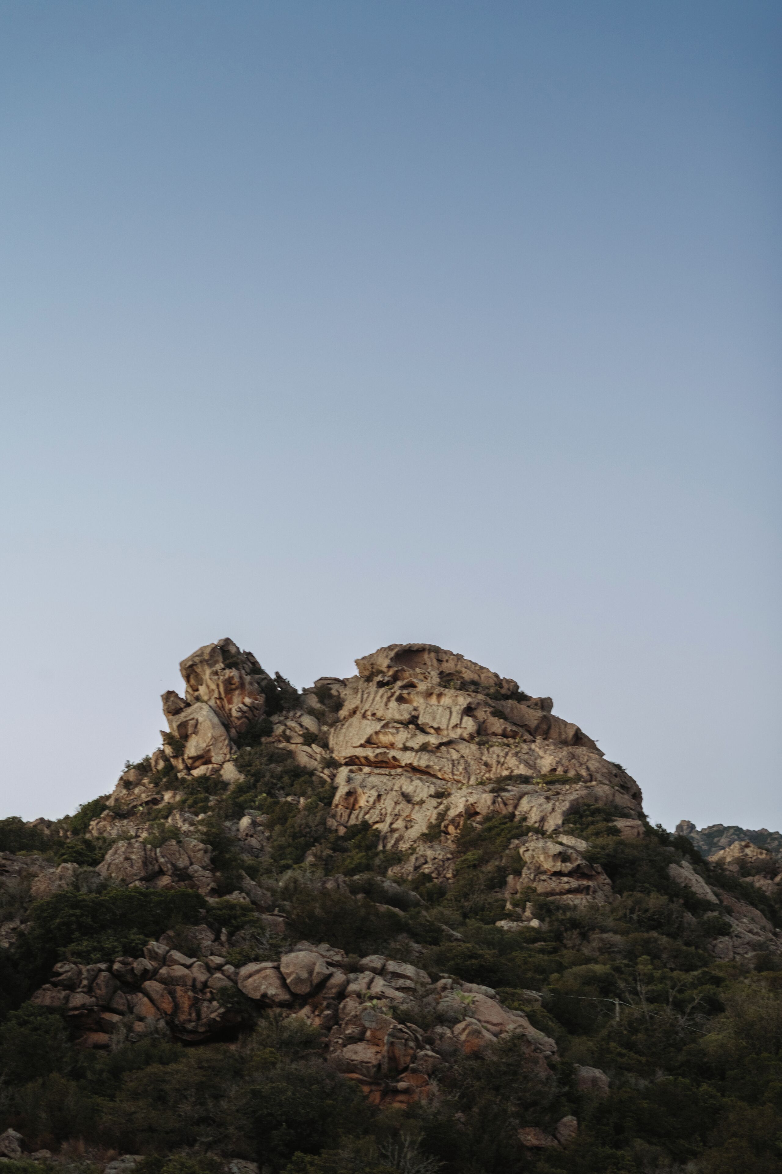 Un paysage montagneux accidenté, caractérisé par des affleurements rocheux et une végétation clairsemée.